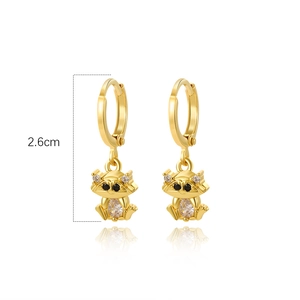 Detail view of 2.6cm golden raccoon huggie earrings with sparkling cubic zirconia