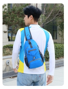 Rear view of model wearing a blue nylon multi-pocket chest bag for outdoor sports use