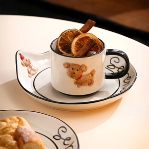 Detail of cream ceramic dog mug with hand-drawn Seoul pattern and cinnamon sticks