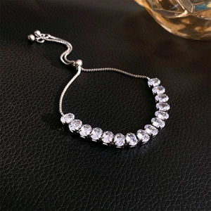 Detailed view of adjustable silver bracelet with oval white zircons on black leather