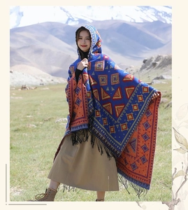 Détail du poncho ethnique à motifs géométriques avec capuche et finitions à franges