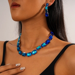 Detail view of model wearing vintage luxury blue crystal necklace and earring jewelry set