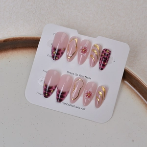 Detail of Y2K crocodile print press-on nails with gold 3D lines and floral motifs