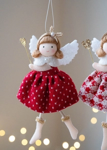Detail of Christmas plush angel doll featuring red polka dot skirt and golden heart wand