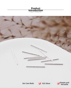 Macro detail of multiple polished s925 sterling silver earring studs on a white surface