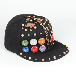 Detail of hiphop flat brim hat with colorful gemstones, golden rivets and cross charms