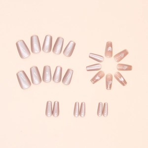 Detail view of pink cat-eye press-on nails with heart patterns and pearl line accents