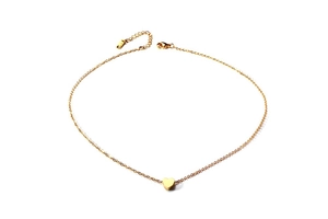 Macro detail of a golden heart pendant necklace with high-gloss polished finish