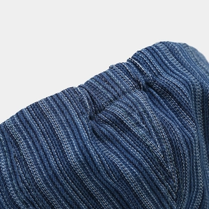 Detailed macro view of deep blue washed denim fabric texture and pleated elastic band
