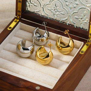 Polished chunky hollow hoop earrings in gold and silver finish set in a wooden jewelry box