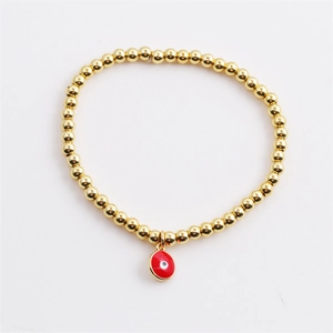 Gold beaded stretch bracelet featuring a colorful enamel evil eye charm on white background
