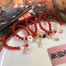 Detail of red agate beaded bracelets with traditional Chinese pendants on a ceramic plate