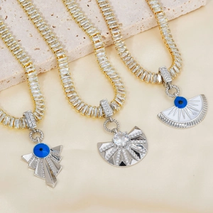 Detailed view of evil eye necklaces with cubic zirconia pendants and gold cuban chains