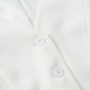 Detailed close-up of premium white vest buttons and smooth woven fabric texture