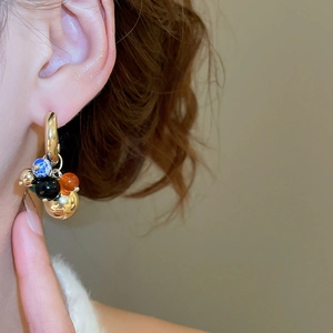 Close-up of vintage grape cluster drop earrings with colorful marble and amber beads