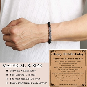 Detail of natural grey map stone beaded bracelet on wrist with a 50th birthday gift card
