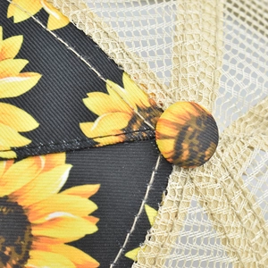 Detailed macro view of black sunflower print fabric and breathable mesh on a cap