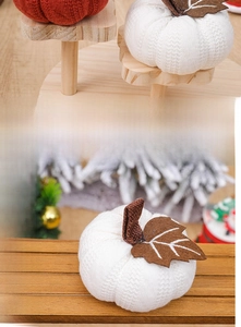 Detail of hand-knitted orange and white pumpkins with realistic leaf and stem textures