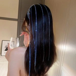 Macro shot of luxury headpiece featuring long blue rhinestone tassels on dark hair