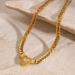 Gold-plated Cuban chain necklace featuring a textured heart pendant on a stone background