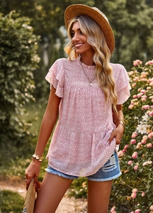 Pink floral top with ruffled cap sleeves and layered hem shown in an outdoor garden