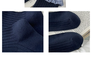 Detail of navy blue knit crew socks with blue and white plaid ruffle trim and cotton texture