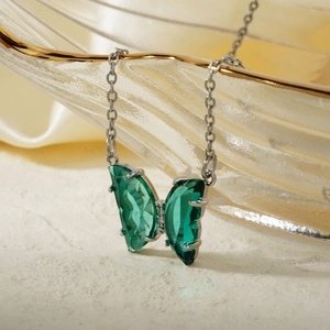 Elegant silver necklace with a butterfly pendant featuring green crystals and diamonds