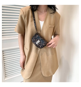 Leopard print crossbody bag detail with silver metal clasp worn on a beige blazer