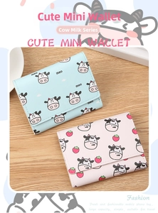 Detail of compact tri-fold wallets featuring cute cow and strawberry prints in pastel colors