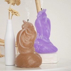 Velas artísticas con forma de dragón con alas y escamas sobre mármol