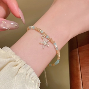 Detailansicht eines Perlenarmbands mit Seestern-Anhänger und blauen Kristallperlen