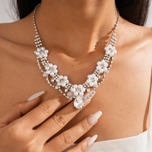 Detail of silver-tone flower necklace featuring faux pearls and water-drop crystal pendant