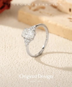 Macro shot of a rectangular 1 carat moissanite silver ring on a textured surface