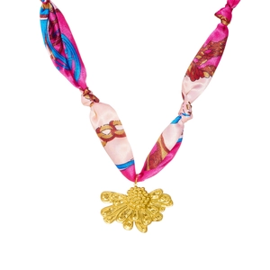 Détail du collier ruban en soie imprimé rose avec son pendentif fleur dorée