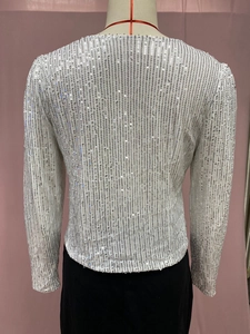 Close-up of silver sequin jacket detailing with vertical striped texture and round neckline