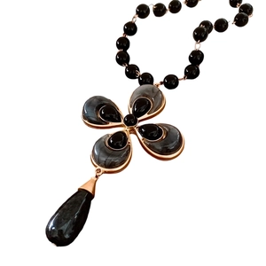 Vintage rose gold necklace set with black flower and teardrop bead charms on white background