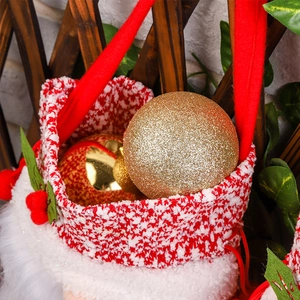 Red and white Christmas gift bag filled with golden glitter baubles for festive tree decor