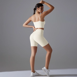 Vista laterale posteriore del set da yoga crema con pantaloncini e reggiseno sport