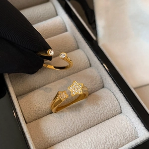 Gold plated open rings with star and round zircon crystals on jewelry box display
