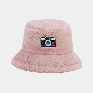 Close-up of pink faux fur bucket hat featuring a camera patch with a heart design