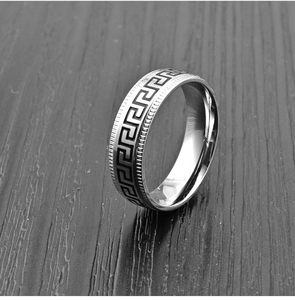 Macro detail of 8mm stainless steel ring with black Greek Key pattern and coin edge texture