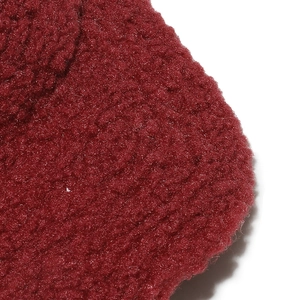 Vue macro de la texture du tissu en laine d'agneau bordeaux sur la casquette