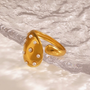 Elegant gold teardrop open ring with embedded white pearls on textured glass