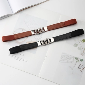 Detail of black and brown elastic waist belts with silver metal chain buckles on a magazine