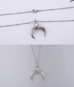 Detailed close-up of a silver crescent moon pendant with a sleek bead chain necklace