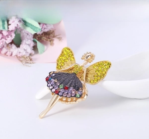 Detail of a vintage gold ballerina brooch with colorful rhinestones on a soft background