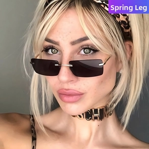 Close-up of rimless rectangular sunglasses with dark lenses and gold metal temples
