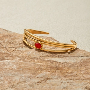 Elegante bracciale aperto dorato multistrato con gemma ovale rossa di lusso