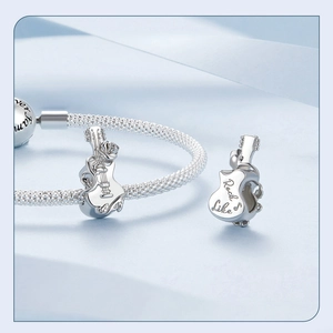 Detailed close-up of a 925 silver guitar charm with rose decor and Rock Like engraving