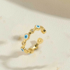 Detailed macro view of gold-plated evil eye ring with blue enamel and zircon stones